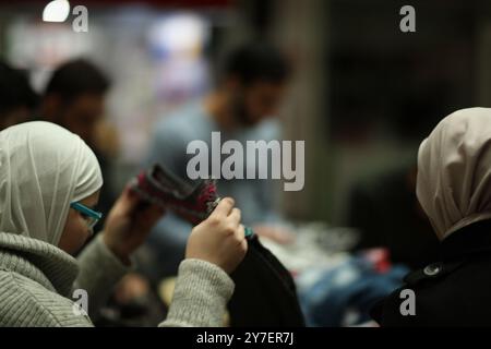 Gaziantep, Syrien. 30. Dezember 2019. Junge syrische Freiwillige sammeln Güter, die an Binnenvertriebene Syrer, die vor den Kämpfen in der Provinz Idlib fliehen, gespendet werden. Kleidung, Decken und Matratzen gehörten zu den Gegenständen, die von Syrern aus der ganzen Türkei gespendet und hauptsächlich von Universitätsstudenten in der südtürkischen Stadt Gaziantep gesammelt wurden, um sie an Syrer zu verteilen, die aus der nordwestlichen syrischen Provinz fliehen. Seit November letzten Jahres drängen die syrischen Regierungstruppen, unterstützt von russischen Kräften, um das letzte von Rebellen gehaltene Territorium der Provinz Idlib zurückzuerobern Stockfoto