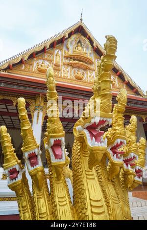 Detaillierte Ansicht eines großen, geschnitzten, bemalten Betons, einer Reihe exotischer Drachenköpfe, Teil eines Treppengeländes. Im Wat Hosantinimit in Vientiane, Laos. Stockfoto