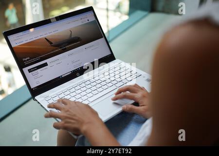 China. September 2024. In dieser Fotoabbildung durchsucht Eine Frau die Cathay Pacific Website auf ihrem Laptop, um den Preis des Flugtickets zu überprüfen. Quelle: SOPA Images Limited/Alamy Live News Stockfoto