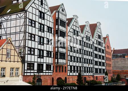 Reihe von bunten Fachwerkhäusern mit Giebeldächern in der Altstadt von Danzig, Polen. Wohnhausfassade mit Balkonen. Appartementgebäude. Mortg Stockfoto