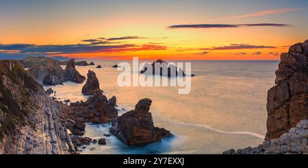 Ein breites 2:1-Panoramafoto von einem Sonnenuntergang an den Felsformationen von Los Urros de Liencres, Teil eines fabelhaften Geologie-Naturparks in Kantabrien in der Nähe des Stockfoto