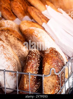 Brot: Verschiedene frisch gebackene Brotprodukte, darunter Baguettes und Brötchen. Brot ist ein Grundnahrungsmittel, das in vielen Kulturen wichtig ist. Stockfoto