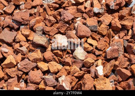 Kleine Stücke von rotem Lehm oder gebrochenem Ziegelstein Hintergrund. Diese Chips, die in der Regel aus Bruchziegeln oder Pflückziegeln hergestellt werden, werden im Gießprozess verwendet Stockfoto