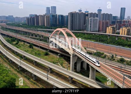 (240930) -- ZHENGZHOU, 30. September 2024 (Xinhua) -- Ein Hochgeschwindigkeitszug fährt auf einer Brücke in Zhengzhou, Zentralchinas Provinz Henan, 30. Mai 2024. Henan liegt strategisch im zentralen Teil des Landes und ist seit Jahrhunderten ein nationaler Verkehrsknotenpunkt. In den vergangenen Jahrzehnten baute die Provinz ein modernes Verkehrsnetz aus Flugzeugen, Eisenbahnen, Autobahnen, Wasserkanälen und allen möglichen Häfen. Sie weitet ihre Rolle nun rasch auf Bereiche der grenzüberschreitenden Logistik, Investitionen und des Handels aus, um den doppelten Umlauf von inländischen und internationalen Märkten zu erleichtern. (Xinh Stockfoto