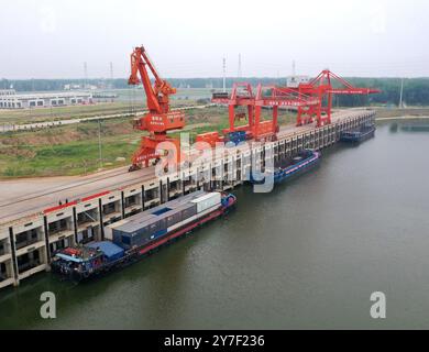 (240930) -- ZHENGZHOU, 30. September 2024 (Xinhua) -- Ein Drohnenfoto zeigt Frachtschiffe, die in einem Hafen im Huaibin County in der zentralchinesischen Provinz Henan ankern, 5. Juni 2024. Henan liegt strategisch im zentralen Teil des Landes und ist seit Jahrhunderten ein nationaler Verkehrsknotenpunkt. In den vergangenen Jahrzehnten baute die Provinz ein modernes Verkehrsnetz aus Flugzeugen, Eisenbahnen, Autobahnen, Wasserkanälen und allen möglichen Häfen. Sie weitet ihre Rolle nun rasch auf Bereiche der grenzüberschreitenden Logistik, Investitionen und des Handels aus, um den doppelten Umlauf von inländischem und inländischem Verkehr zu erleichtern Stockfoto