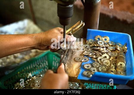 Herstellung traditioneller balinesischer Münzen mit Hohlraum, bekannt als „pis bolong/jinah bolong/uang kepeng“, im Dorf Kamasan, Klungkung, Bali, Indonesien. Stockfoto