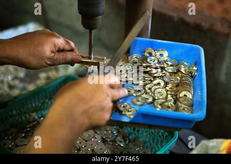 Herstellung traditioneller balinesischer Münzen mit Hohlraum, bekannt als „pis bolong/jinah bolong/uang kepeng“, im Dorf Kamasan, Klungkung, Bali, Indonesien. Stockfoto