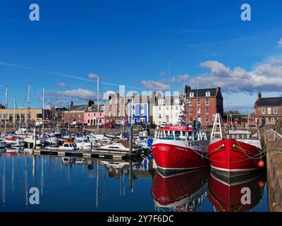 Blick auf den inneren Hafen und die Marina von Arbroaths Fishing Port, mit Yachten in der Marina und zwei traditionellen Fischereifahrzeugen gebunden. Stockfoto