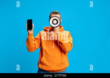 Mit Megaphon und Smartphone in der Hand setzt man ein starkes Statement, um moderne Kommunikation in den Fokus zu rücken. Stockfoto