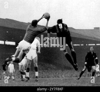 Manchester United Torhüter Harry Gregg springt auf und rettet den Ball vor dem Kopf des Mailänder Mittelstürmers Juan Schiaffino während eines Mailand-Angriffs im Halbfinale des Europapokals im ersten Legspiel zwischen Manchester United und Milan in Old Trafford. Mai 1958. Stockfoto