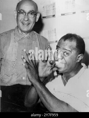 Louis Armstrong spielt eine imaginäre Trompete aus seinem Bett im Spoleto Krankenhaus neben ihm ist der Arzt Alexander Schiff im Juni 1959 Stockfoto