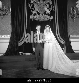 Prinzessin Alexandra von Kent trägt ein Kleid aus Magnolien-getönter Spitze, bestickt mit Eicheln und Eichenblättern mit einem Zug von 20 Fuß Länge, posiert mit ihrem neuen Ehemann Angus Ogilvy im Thronsaal des St. James' Palace nach ihrer Heirat in der Westminster Abbey. April 1963 Stockfoto