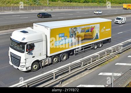 dfs Möbel Business Advertising Grafik in voller Länge, Gelenkanhänger, der Autofahrern auf der achtspurigen Autobahn M25 Essex England (Großbritannien) ausgesetzt ist Stockfoto