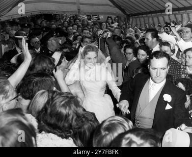 Pünktlich zur Kirche kommen - Weybridge, Surrey, 10. Mai 1959 - der Vater der Braut scheint besorgt zu sein, dass er und sie pünktlich zur Kirche kommen sollten, trotz des Schmerzes von Menschen draußen. Mr. Andrews hält seine liebenswerte Tochter Julie Andrews, Star von "My Fair Lady", bei der Hand, als sie heute in der Oatland St. Mary Church ankommen, für ihre Heirat mit ihrem Liebsten Tony Walton. Der Empfang, der noch überfüllter war als die Hochzeit, fand im Mitre Hotel in Hampton Court statt. Stockfoto