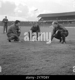 Das Team der West Ham Utd kommt im West Ham Greyhound Stadium zu einem Training auf dem üppigen Gras, das dem des Wembley Stadions ähnelt, wo sie am 2. Mai im Finale auf Preston North End treffen werden. Hier sehen Sie von links nach rechts: Roger Byrne der Mittelstürmer, Bobby Moore, Kapitän und Halbrückwärter, und Manager Ron Greenwood. April 1964. Stockfoto