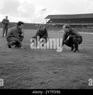 Das Team der West Ham Utd kommt im West Ham Greyhound Stadium zu einem Training auf dem üppigen Gras, das dem des Wembley Stadions ähnelt, wo sie am 2. Mai im Finale auf Preston North End treffen werden. Hier sehen Sie von links nach rechts: Roger Byrne der Mittelstürmer, Bobby Moore, Kapitän und Halbrückwärter, und Manager Ron Greenwood. April 1964. Stockfoto