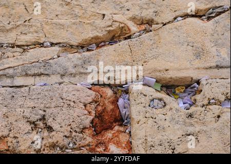 Winzige Zettel mit geschriebenen Gebeten zu Gott werden in die Risse der Westmauer in Jerusalem, Israel, eingefügt. Stockfoto