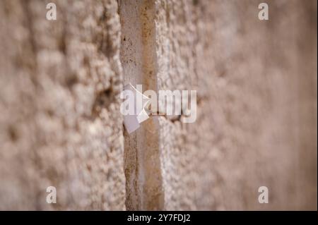 Winzige Zettel mit geschriebenen Gebeten zu Gott werden in die Risse der Westmauer in Jerusalem, Israel, eingefügt. Stockfoto