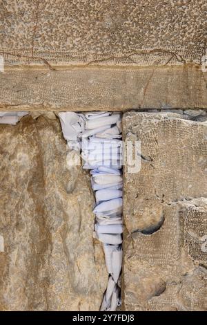 Winzige Zettel mit geschriebenen Gebeten zu Gott werden in die Risse der Westmauer in Jerusalem, Israel, eingefügt. Stockfoto