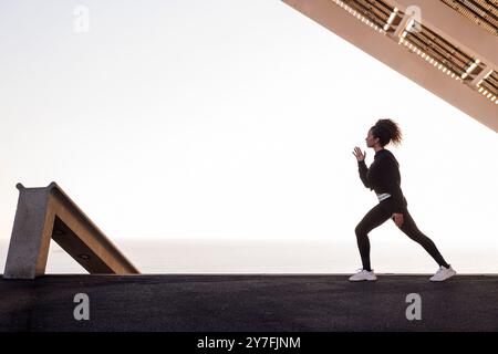 Athlet, der während des Trainings seitlich hockt Stockfoto
