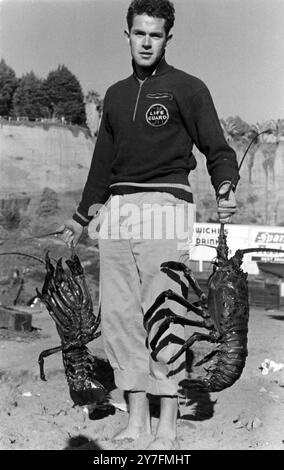 Ein Rettungsschwimmer am Santa Monica Beach mit einem Hummer in Kalifornien in den 1940ern Der Strand war der nächstgelegene Küstenstreifen zu Hollywood und war berühmt für die kräftigen und gutaussehenden Rettungsschwimmer, die den Sand patrouillierten. Stockfoto