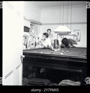 Roger Moore 1958. Im britischen Haus, das er mit seiner Frau Dorothy Squires teilte, The Mount, Wansunt Road, Bexleyheath. Mit Schauspieler Robert Brown rechts und Sänger Gary Miller, dritter von links. Stockfoto