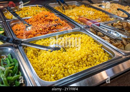 Bar mit warmen Speisen im Supermarkt. Schaufenster eines kulinarischen Ladens. Nahaufnahme von Hot Bar Food in Tabletts im lokalen Store Foods Market. Supermarkt verschiedene Foo Stockfoto