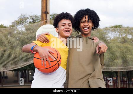 teenager-Freunde lachen glücklich mit Basketball Stockfoto