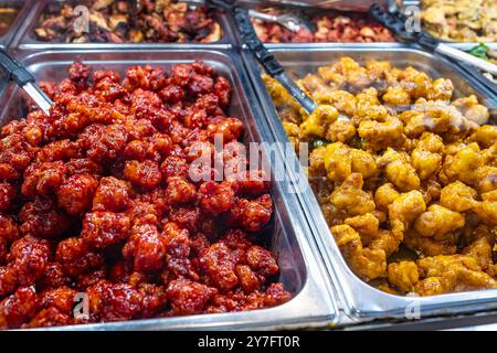 Bar mit warmen Speisen im Supermarkt. Schaufenster eines kulinarischen Ladens. Nahaufnahme von Hot Bar Food in Tabletts im lokalen Store Foods Market. Supermarkt verschiedene Foo Stockfoto