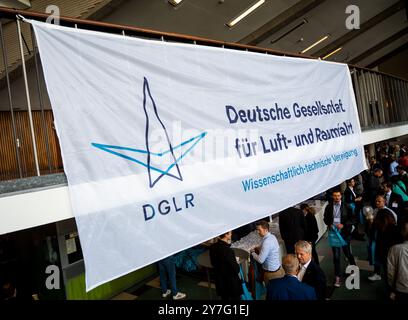 Hamburg, Deutschland. 30. September 2024. Besucher stehen auf dem von der Deutschen Gesellschaft für Luft- und Raumfahrt (DGLR) veranstalteten Deutschen Kongress für Luft- und Raumfahrt in Hamburg. Drei Tage lang treffen sich Wissenschaftler, Branchenvertreter und Interessenten der Luft- und Raumfahrt in Hamburg. (Zu dpa 'Deutscher Luft- und Raumfahrtkongress beginnt in Hamburg') Credit: Daniel Bockwoldt/dpa/Alamy Live News Stockfoto