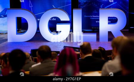 Hamburg, Deutschland. 30. September 2024. Besucher sitzen im Saal des Deutschen Luft- und Raumfahrtkongresses in Hamburg, der von der Deutschen Gesellschaft für Luft- und Raumfahrt (DGLR) organisiert wird. Drei Tage lang treffen sich Wissenschaftler, Branchenvertreter und Interessenten der Luft- und Raumfahrt in Hamburg. (Zu dpa 'Deutscher Luft- und Raumfahrtkongress beginnt in Hamburg') Credit: Daniel Bockwoldt/dpa/Alamy Live News Stockfoto