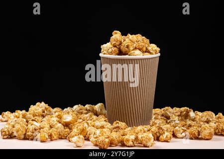 Süßes karamelisiertes Popcorn in einem Eimer. Schwarzer Hintergrund. Platz für Text. Stockfoto