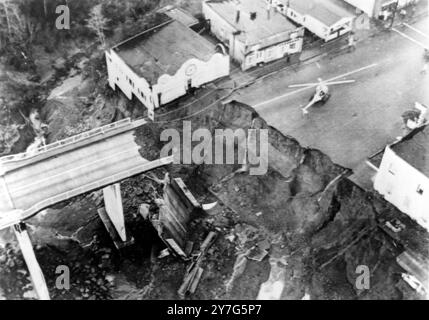 27. DEZEMBER 1964 eine Luftaufnahme, die zeigt, wie das Hochwasser des Eel hoch genug stieg, um die Brücke und ein Gebäude vom Fluss wegzuspülen. Ein Rettungshubschrauber ist auf der Straße zu sehen. Rio Dell, Kalifornien, USA. Stockfoto