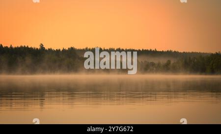 Sonnenaufgang mit Nebel über einem See in Schweden, bei Sonnenaufgang. Romantische Stille, in skandinavischer Natur Stockfoto