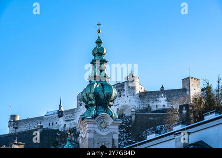 Turm der Stiftskirche St. Peter in der Altstadt von Salzburg, Österreich, mit Blick auf die Festung Hohensalzburg. Stockfoto