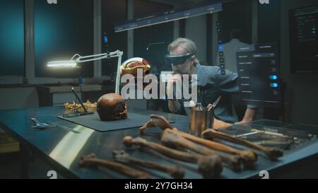 Fortgeschrittenes archäologisches Labor: Archäologe in VR-Headset untersucht alte menschliche Anatomie in Augmented Reality mit fossilem Schädel. 3D-Rendering der virtuellen Anzeige mit Benutzeroberfläche der Scansoftware. Stockfoto
