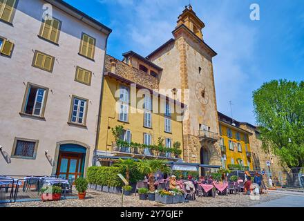 Piazza Lorenzo Mascheroni mit mittelalterlichem Campanella- oder Zitadellenturm und gemütlichem Essen im Freien davor, Citta Alta, Bergamo, Italien Stockfoto