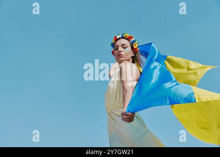 Junge ukrainische Frau mit Nationalflagge im Hintergrund Stockfoto