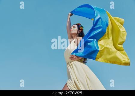 Selbstbewusste ukrainische Frau mit Nationalflagge im Hintergrund Stockfoto