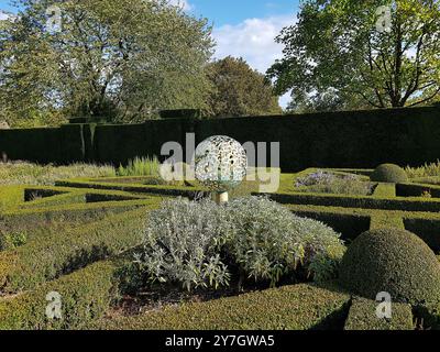 Blick auf einen historischen Garten mit einer Skulptur in der Grafschaft Suffolk, Großbritannien. Stockfoto