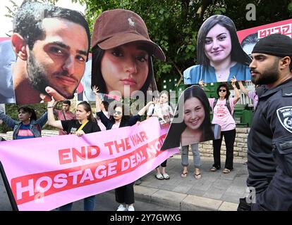 Jerusalem, Israel. 30. September 2024. Eine israelische Polizei bewacht Familien und Unterstützer israelischer Geiseln, die von der Hamas in Gaza festgehalten werden, und hält Plakate mit Fotos von Geiseln und Mitgliedern der israelischen Regierung, während sie am Montag, den 30. September 2024, vor der Residenz des israelischen Ministerpräsidenten Benjamin Netanjahu in Jerusalem protestiert. Die Demonstranten fordern, dass Netanjahu einen Deal zur Rückgabe der Geiseln an ihre Familien für Rosch Hashanah, das jüdische Neujahrsfest, das am 2. Oktober 2024 bei Sonnenuntergang beginnt. Die Demonstranten halten Premierminister Netanjahu persönlich verantwortlich für das Scheitern der Verhandlungen für die r Stockfoto