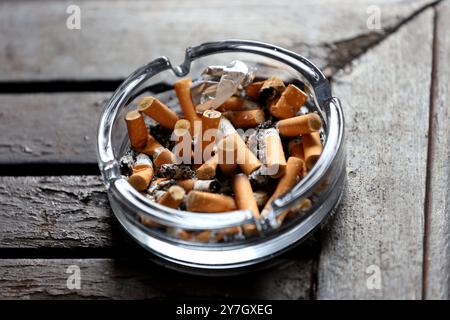 Ein Aschenbecher gefüllt mit Zigarettenkippen und Asche in einem Hotel in Hayling Island, Hampshire, Großbritannien. Stockfoto