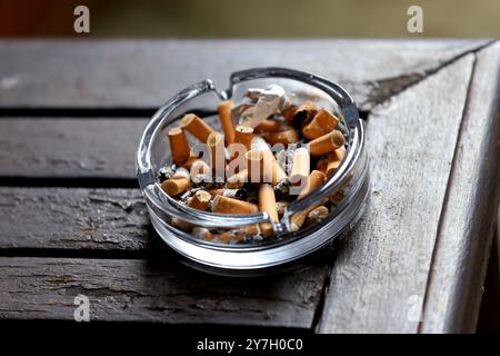 Ein Aschenbecher gefüllt mit Zigarettenkippen und Asche in einem Hotel in Hayling Island, Hampshire, Großbritannien. Stockfoto