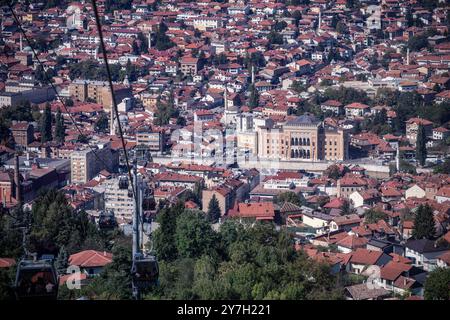 Blick auf die Altstadt von Sarajevo mit der Seilbahn 21.09.24, Sarajevo: Symbolfoto, Illustrationsbild, Symbolbild, Illustrationsfoto, Alltagsszene Blick auf die Altstadt von Sarajevo mit der Seilbahn eine atemberaubende Aussicht auf die Altstadt von Sarajevo, mit der berühmten Nationalbibliothek VijeÄnica im Zentrum und den roten Dächern der umliegenden Häuser. Die Seilbahn führt von TrebeviÄ direkt über die Stadt und bietet eine spektakuläre Vogelperspektive auf die historischen Gebäude und Straßen. . Sarajevo Bosnien-Herzegowina *** Blick auf die Altstadt von Sarajevo mit der Seilbahn 21 09 24, Sa Stockfoto