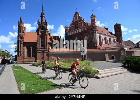 Vilnius, Litauen - 22. Juli 2024: Ein Volk auf Fahrrädern in der Nähe der St. Annenkirche und der Kirche der Heiligen Franz von Assisi und Bernardine. Stockfoto