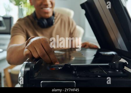 Nahaufnahme eines glücklichen multirassischen Mannes, der Schallplatten auf dem Plattenspieler platziert Stockfoto