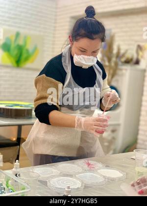 Frau macht in der Werkstatt handgefertigte Epoxidharzplatten Stockfoto