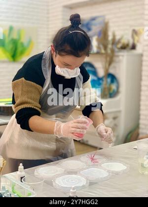 Frau macht in der Werkstatt handgefertigte Epoxidharzplatten Stockfoto