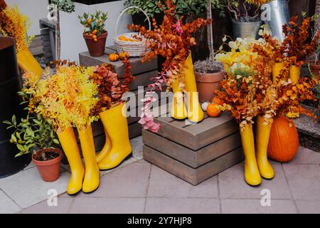 Halloween Dekoration mit Kürbissen und Gummistiefeln vor einem Blumenladen an einem Herbsttag. Stockfoto