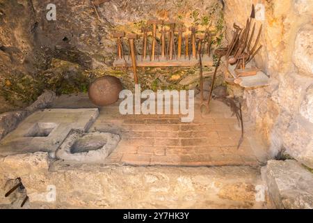 Ausstellung für Touristen mit traditionellem Werkzeug und Ofen, unterstützt von Luftbälgen in der Black Smiths Werkstatt im Krka Nationalpark. Kroatien. (138) Stockfoto